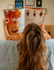 child reading book on sofa with artwork hanging on wall in background
