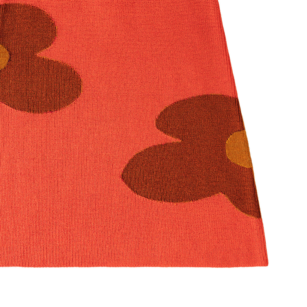 Close-up of a red fabric with brown floral patterns