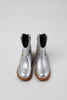 silver cowboy boot with gold and black stars on grey background.