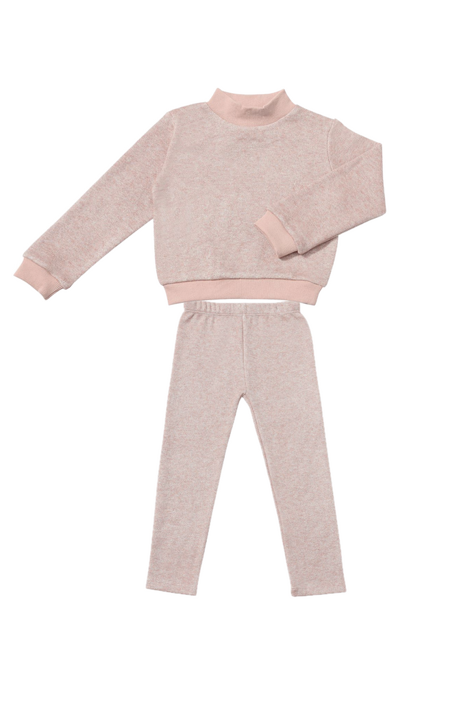 Pink sweater and pants set on a white background